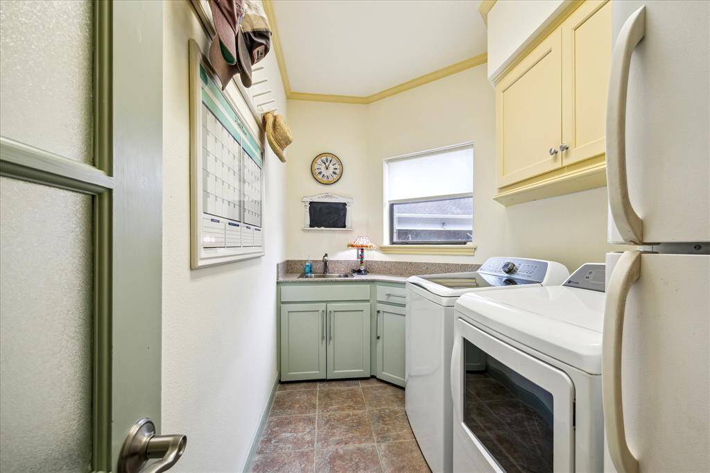 Laundry room conveniently located between the kitchen and garage space. Room for a second fridge and has a sink.