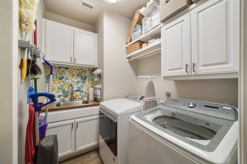 The first floor Laundry Room features a soaking sink, cabinets and a hanging rack