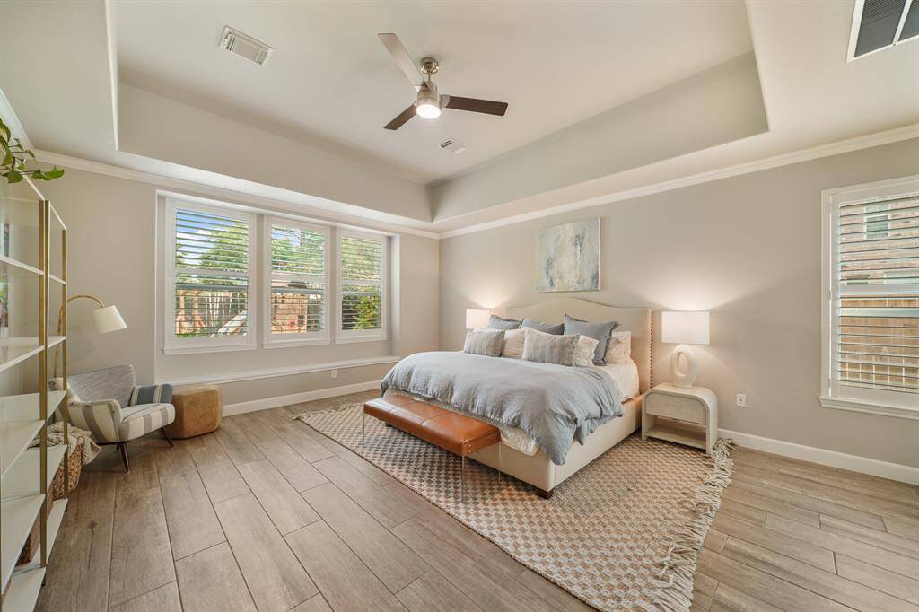 First floor Primary Bedroom with a tray ceiling and views of the backyard