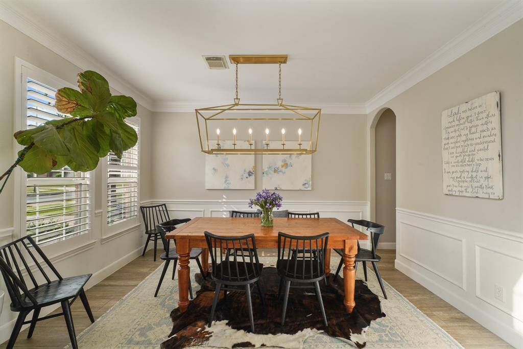 The Formal Dining Room features wainscotting, crown molding and a beautiful chandelier