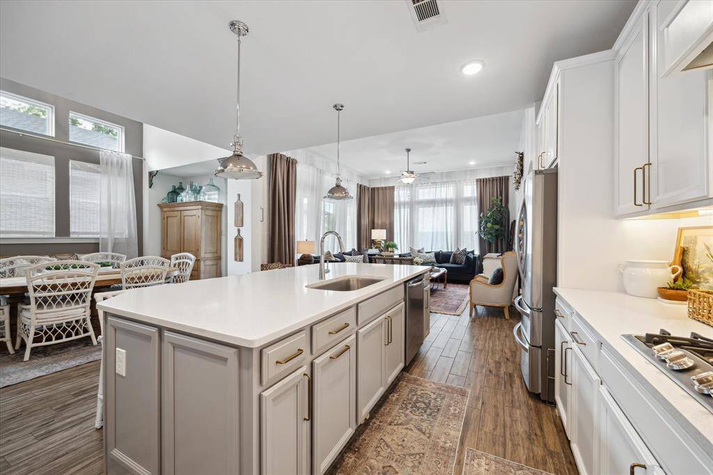 Tons of cabinets meet stunning designer lighting to create a kitchen that’s both practical and gorgeous.
