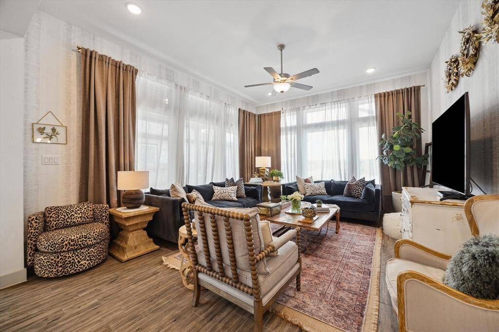 Bathe in natural light in this stunning living room, where soft, neutral tones create a warm and inviting ambiance, beautifully complemented by expansive windows that frame serene outdoor views.