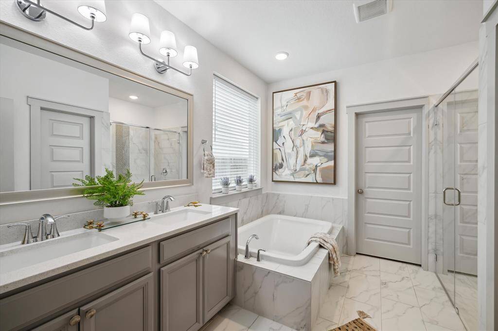 Indulge in relaxation with a stunning primary bath featuring a luxurious soaking tub and a spacious walk-in shower, designed for both comfort and elegance.