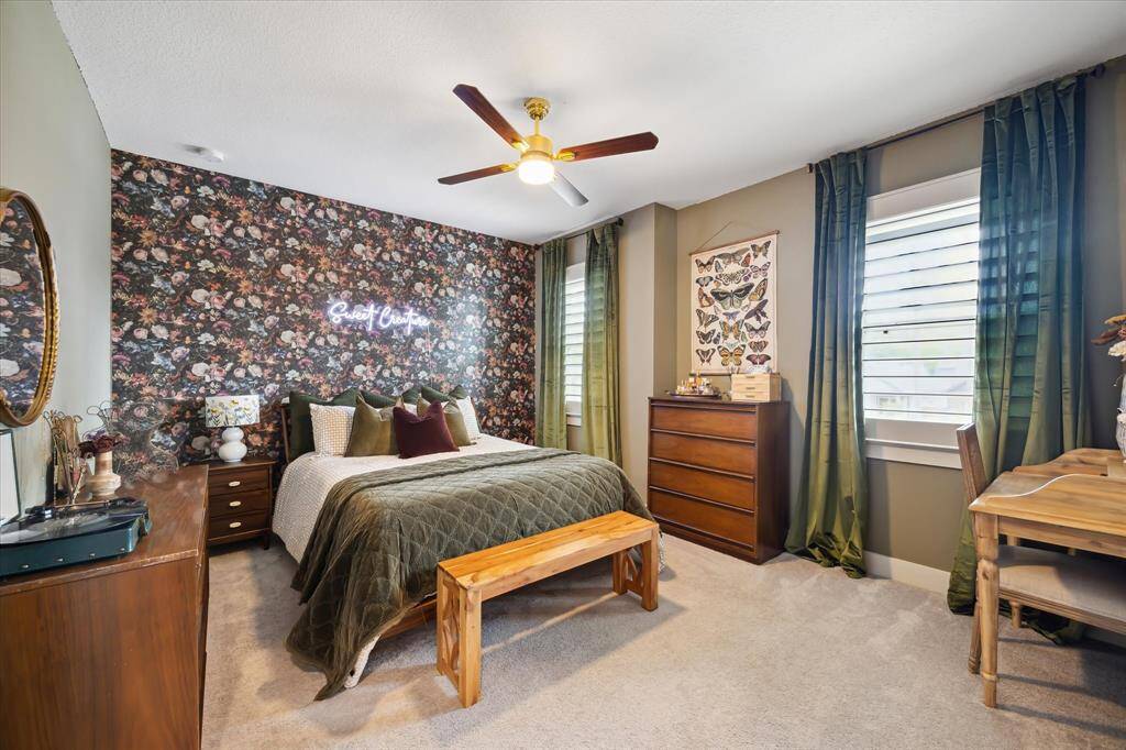 This bedroom stuns with designer wallpaper and custom curtains that add a touch of luxury and personality.