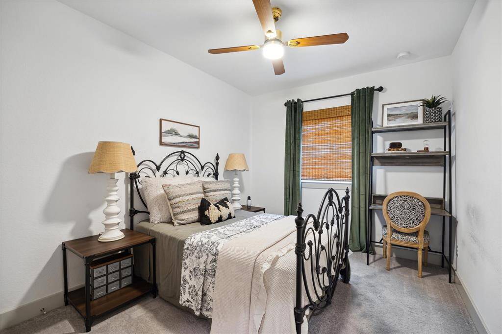 The secondary bedroom offers a serene retreat, featuring soft neutral tones that create a calming atmosphere, perfect for relaxation and personal style.