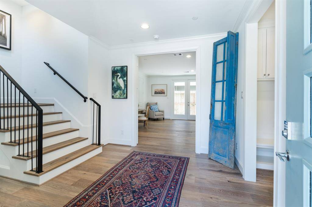 The front foyer is like a room flooded with light from the open stairwell and a convenient mud room with cabinets to the right.