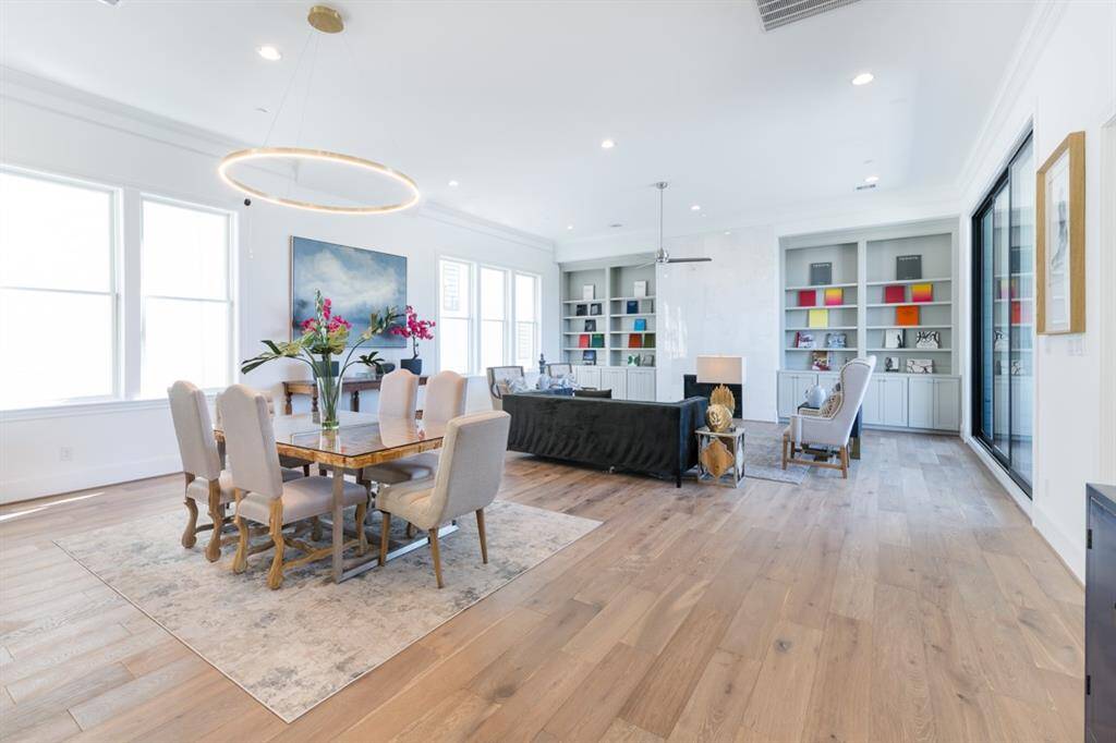Refined style with clean lines, built-in bookcases, natural stone fireplace, tall ceilings, 10’ sliding glass doors and eye-catching chandelier.