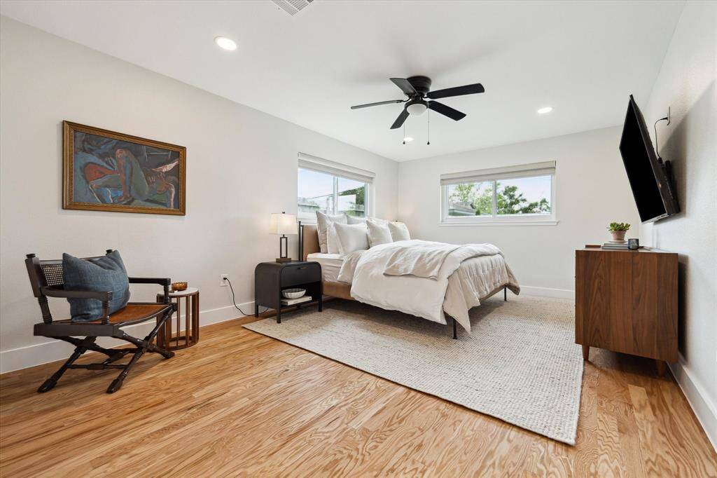 The PRIMARY BEDROOM -  17.5 X 12 - has two windows with custom shades, rich wood flooring, and nice space to accommodate your furnishings comfortably.