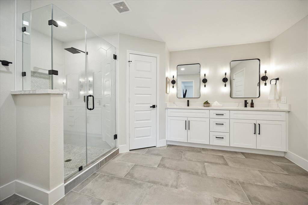The fabulous primary bath features a spacious glass-enclosed shower, a double vanity with quartz countertops, and 24'x12" tile flooring. A separate water closet adds privacy and includes a new high-end Woodbridge Washlet toilet—luxurious and high-tech!