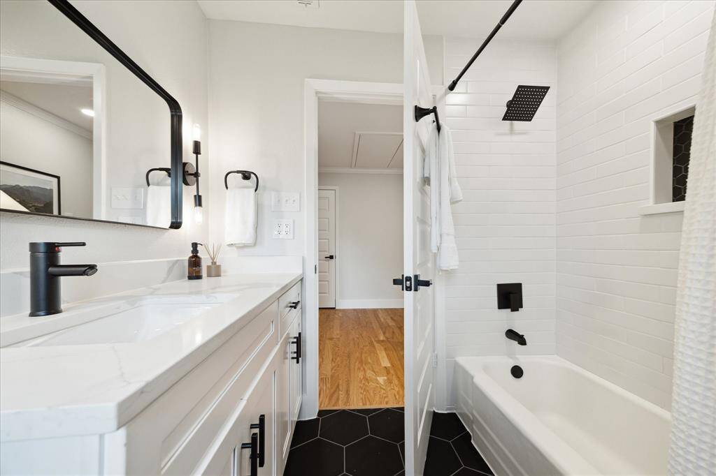 This angle of the full bath highlights the tub and shower combo, beautifully accented with a classic subway tile surround and a built-in niche—perfect for keeping bath essentials organized!