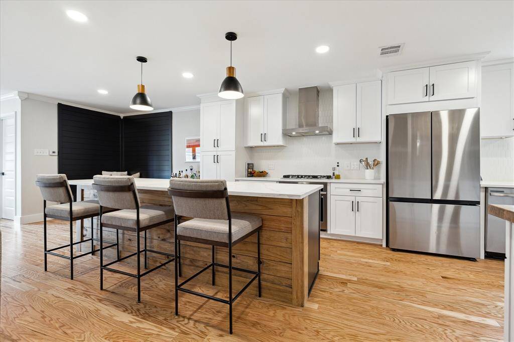 The spacious kitchen is a standout, featuring all-new appliances and designed with the avid cook in mind. A 5-burner gas cooktop with a stainless vent hood, while quartz countertops and abundant cabinetry offer great storage.