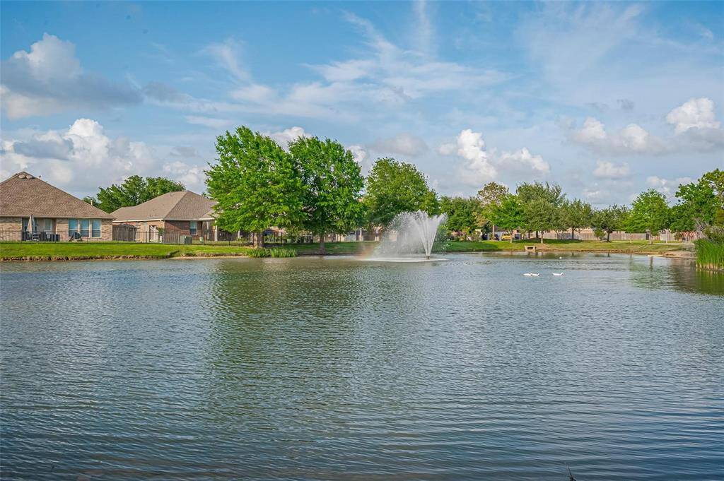 Waterstone showcases a serene lake with a central fountain, bordered homes and lush greenery, offering a peaceful and picturesque view for potential home buyers.