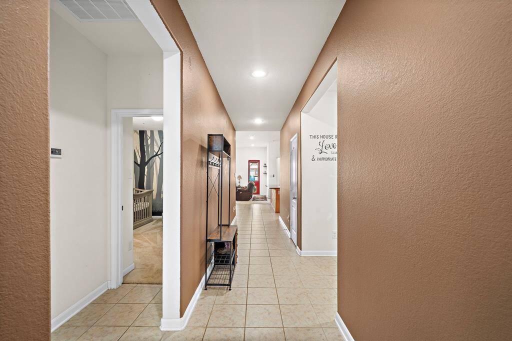 Stepping into this charming home featuring two secondary bedrooms and a convenient bathroom to the left.