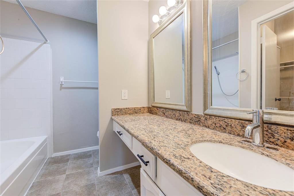 Relax in an updated primary bath featuring modern fixtures, a walk-in shower, and a sleek vanity. Enjoy the perfect blend of style and convenience.