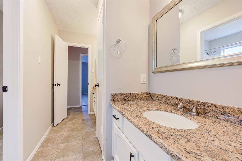 The hall bath features tasteful updates, including a stylish vanity and a comfortable tub/shower combo for family and guests.