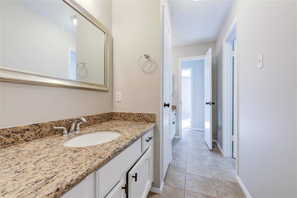 The hall bath features tasteful updates, including a stylish vanity and a comfortable tub/shower combo for family and guests.