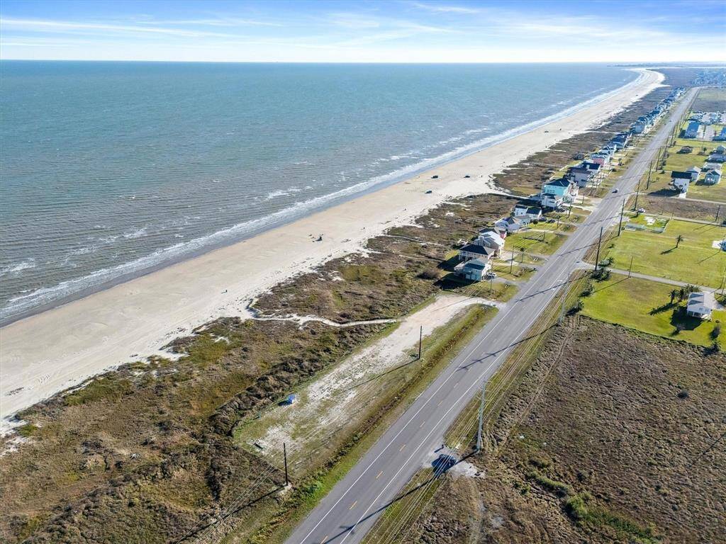 Birds eye view of property featuring a beach view and a water view
