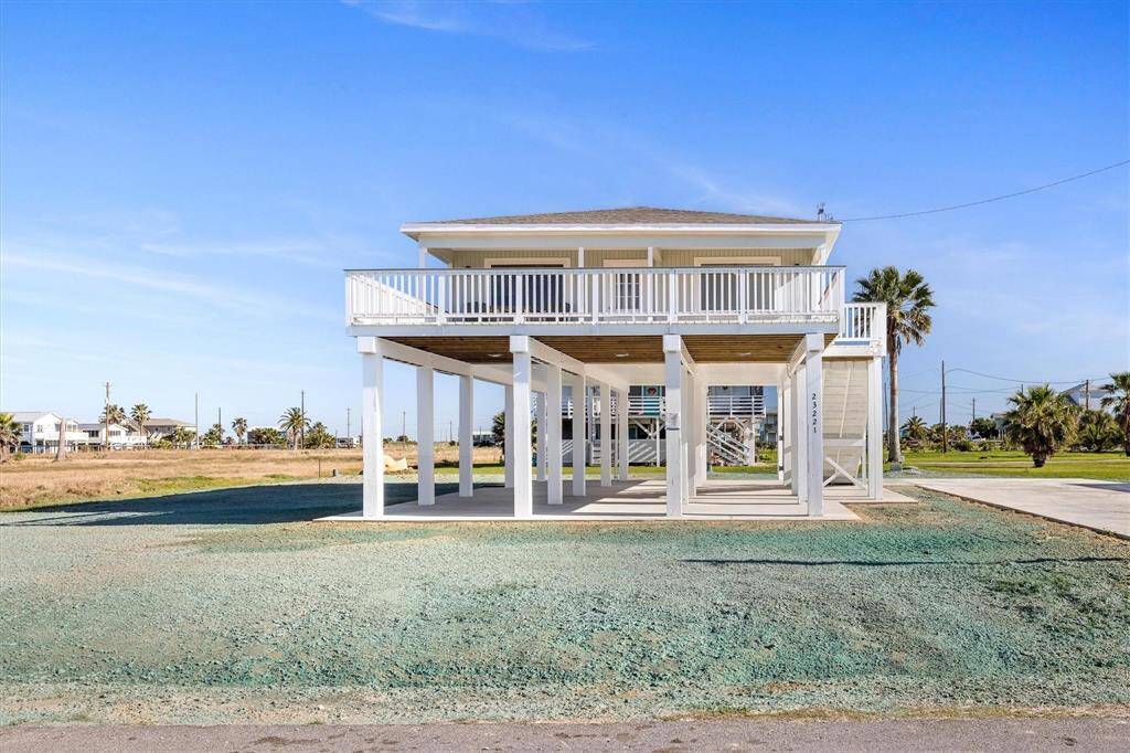 View of front of property featuring a carport and stairs