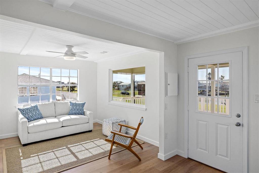 Foyer with ornamental molding, a ceiling fan, baseboards, and wood finished floors