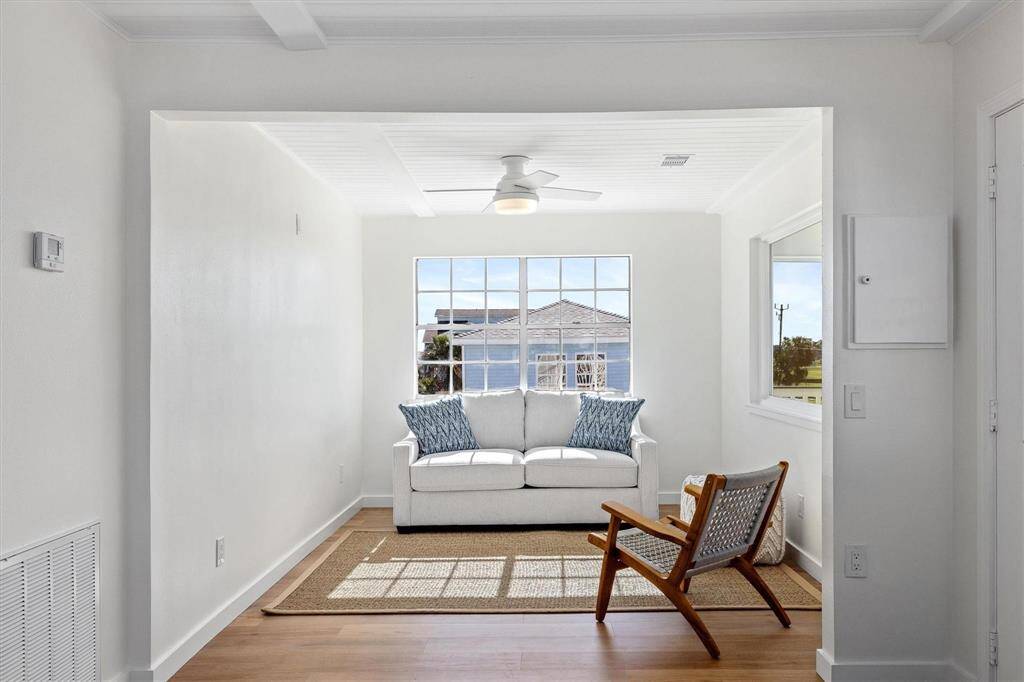 Living area featuring a ceiling fan, wood finished floors, visible vents, and a wealth of natural light