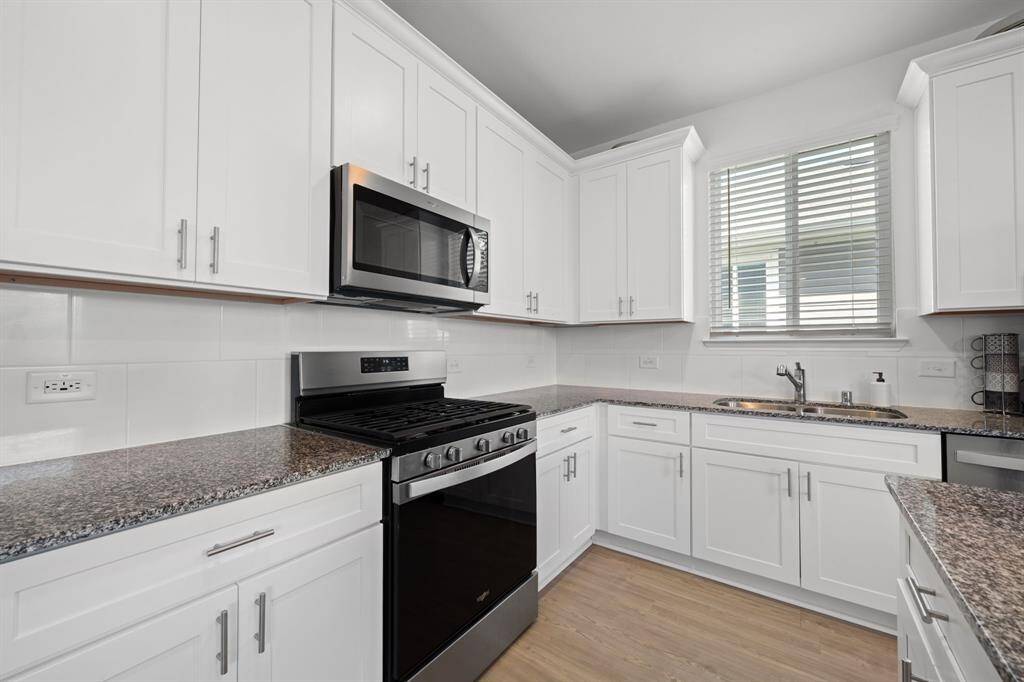 Equipped with a 5-burner gas range and sleek granite countertops, the kitchen blends performance with style.