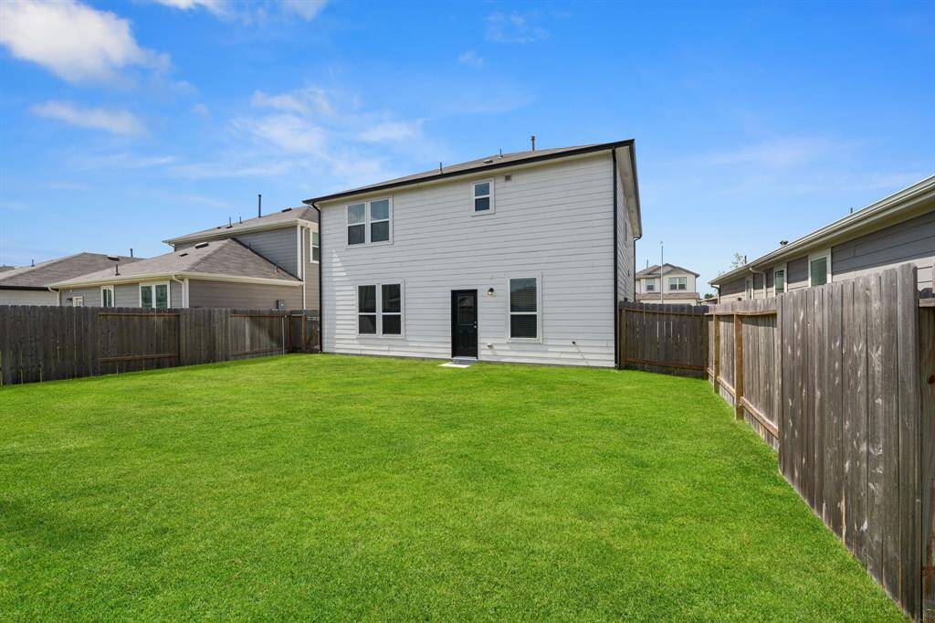 Cozy backyard features a low-maintenance concrete slab, ideal for a patio setup or utility use. A compact outdoor space perfect for simple living.