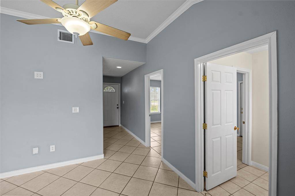 Hallway facing front door splits to flex room, bathroom and utility