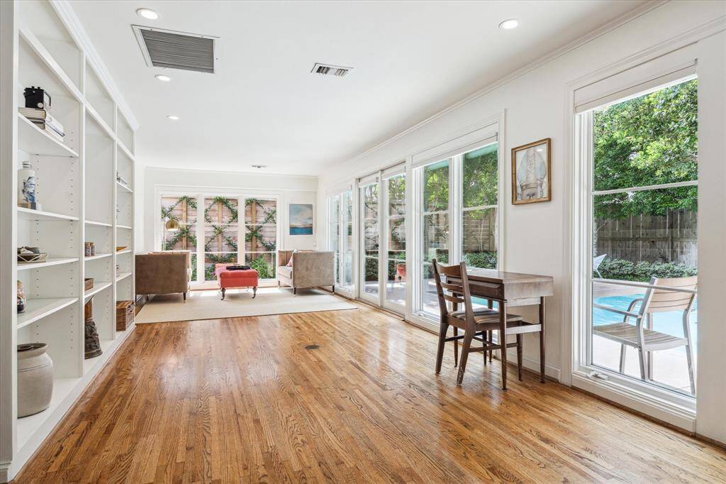 Walls of floor-to-ceiling windows frame the expansive den at the rear of the home, inviting the outdoors in.