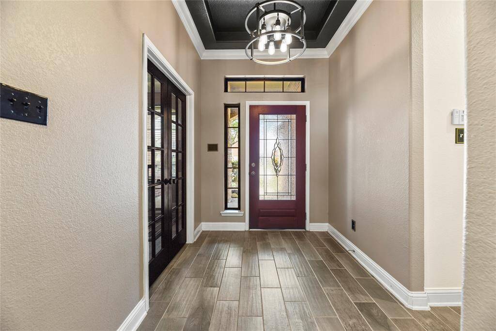 From the foyer with its stylish trayed ceiling, enjoy a clear view into the home office through elegant double glass doors—creating a welcoming and open feel right from the entry.