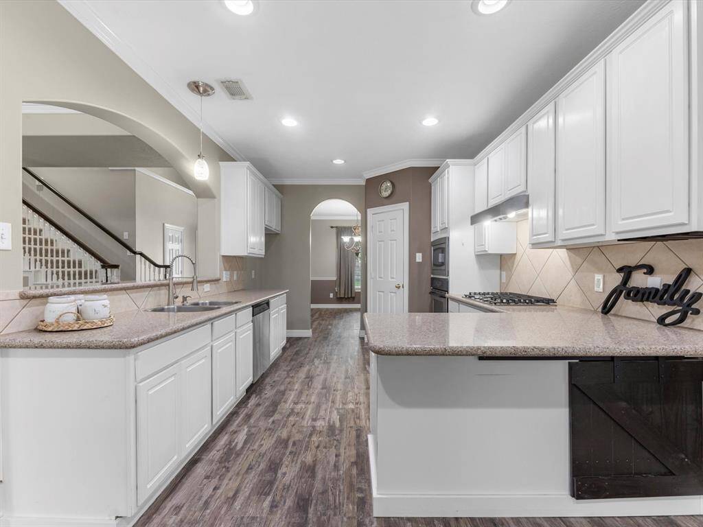 The kitchen is updated with granite counters, white cabinets and stainless appliances