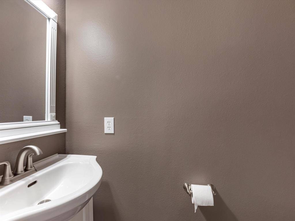 The powder room is tucked up near the stairs for privacy