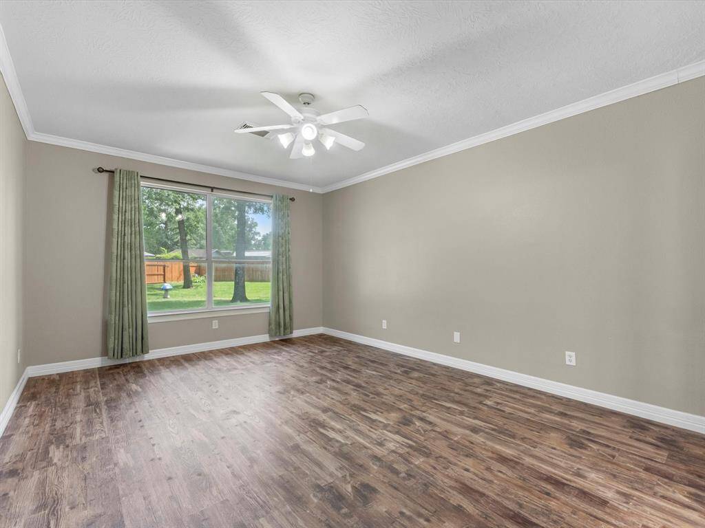A beautiful primary bedroom with plenty of space. The laminate floors carry through here along with crown moulding