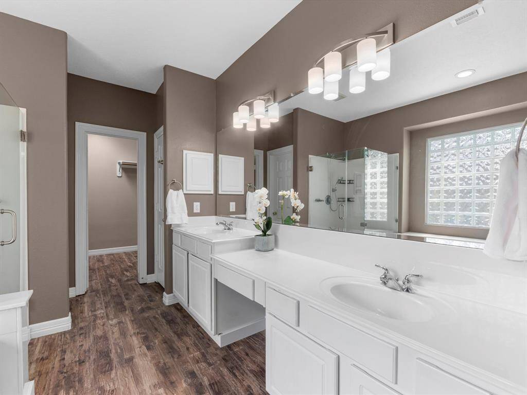 This ensuite bath has been nicely updated with light and plumbing fixtures, white cabinets and the laminate floors