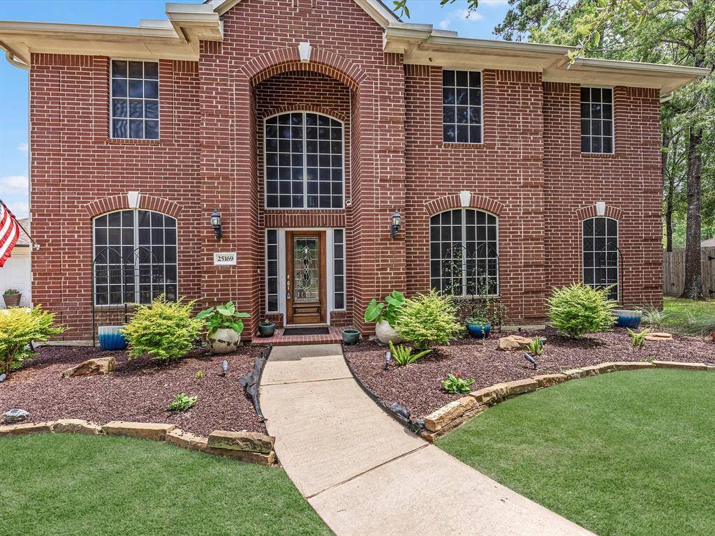 The covered entry way is inviting with beautiful landscaping