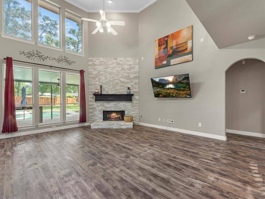 A cozy gas log fireplace with stone surround is a pretty focal point in this family room