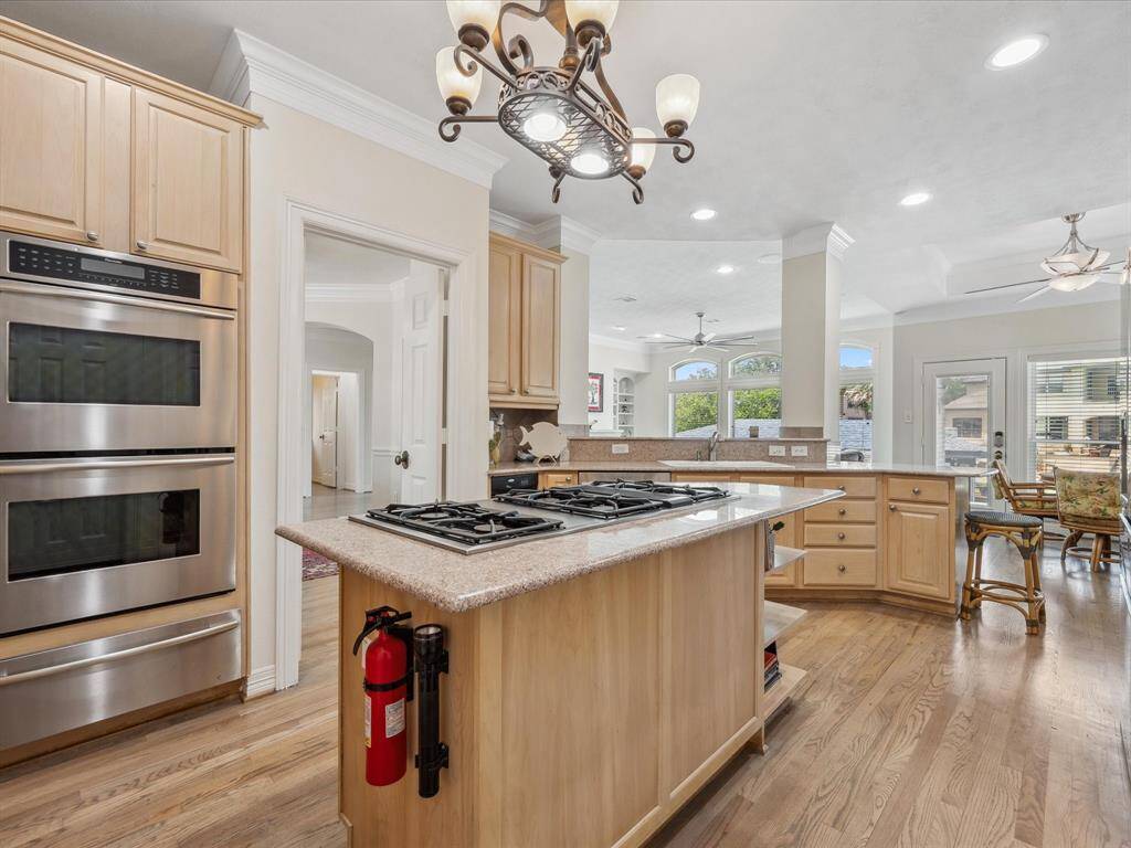 THE DINING ROOM AND DEN OPEN TO THE ISLAND KITCHEN COMPLETE WITH DOUBLE STAINLESS-STEEL OVENS AND WARMING DRAWER.