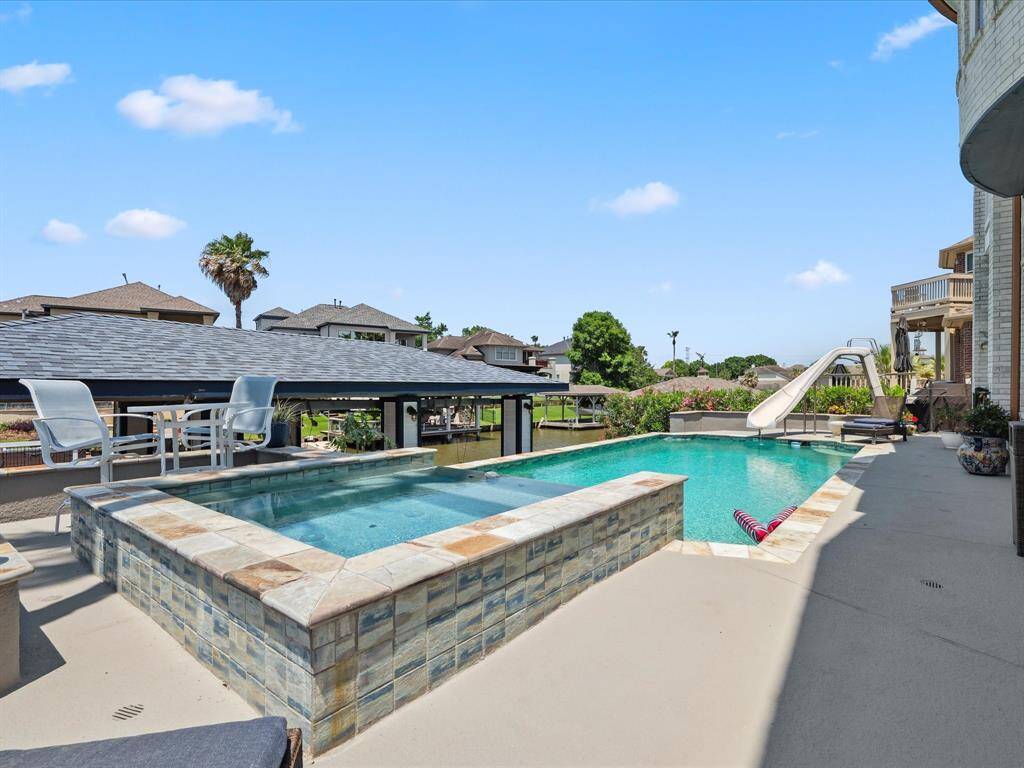 TROPICAL SALTWATER POOL FEATURING A SPA AND WATERSLIDE.
