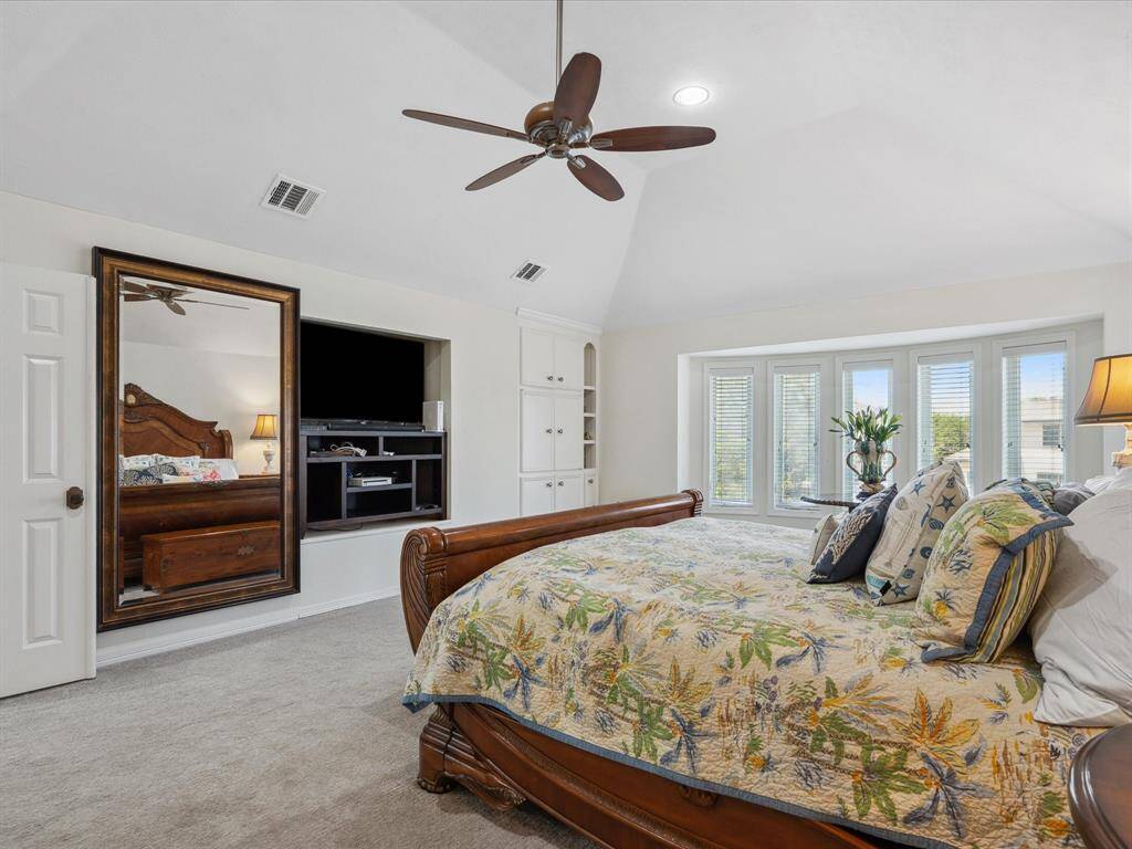 THE PRIMARY SUITE ALSO FEATURES CUSTOM BUILT-INS AND ACCESS TO A PRIVATE BALCONY OVERLOOKING THE WATER.