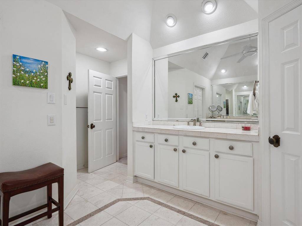 HIS AND HER VANITIES FEATURE BEVELED EDGE FRAMED MIRRORS.