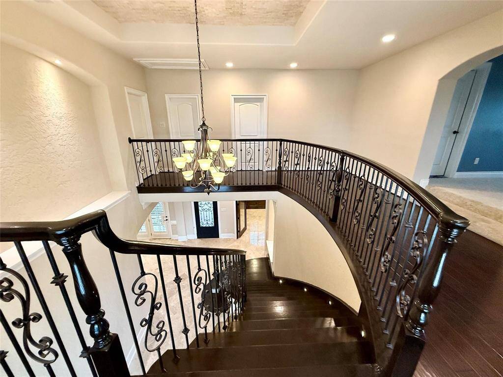 Gorgeous view of this stairs case to upstairs with wrought iron railing.