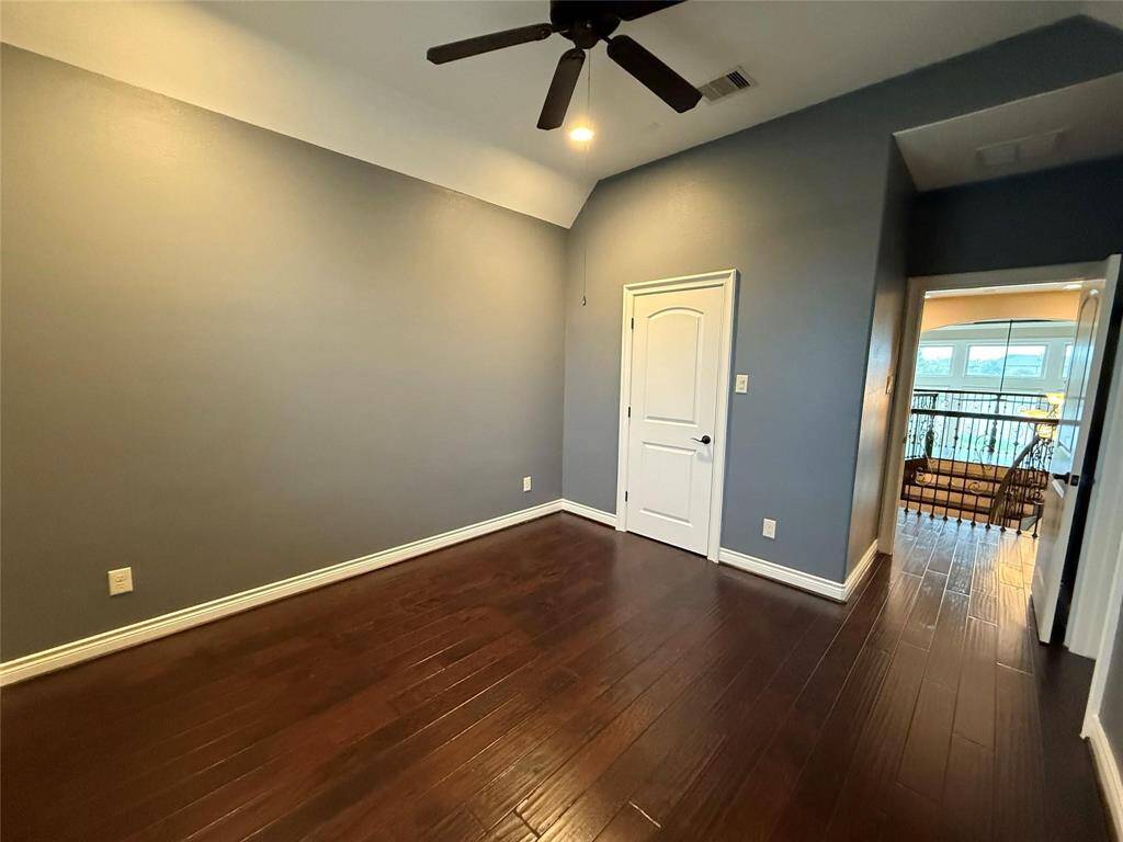 Upstairs bedroom offers rich hardwood floor, ceiling fan and its own bathroom.