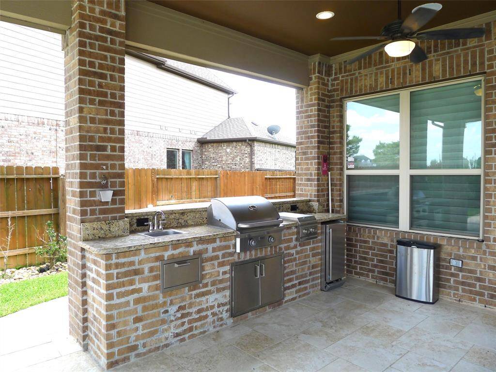 This outdoor kitchen with  built-in grill, countertop, sink and an ice maker for you to entertain your guests.