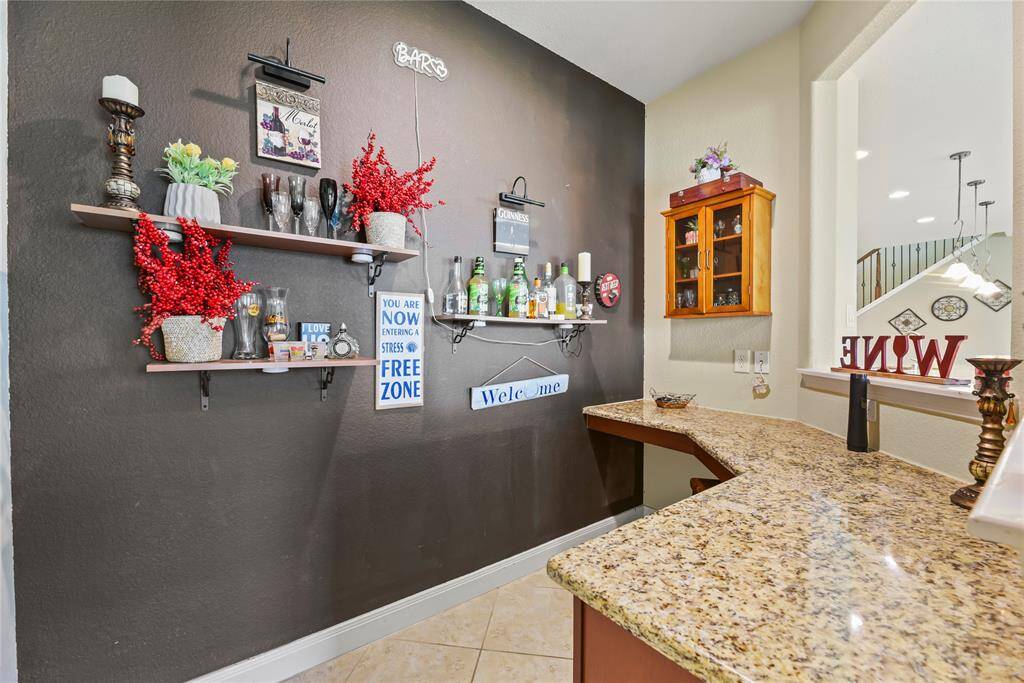 A cleverly integrated bar nestled within the kitchen area offers the perfect blend of style and functionality, ideal for entertaining guests.