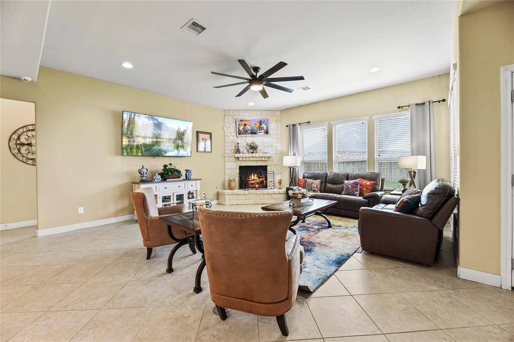 At the heart of the space, a grand limestone fireplace anchors the room with warmth and sophistication—perfect for both quiet evenings and stylish gatherings.
