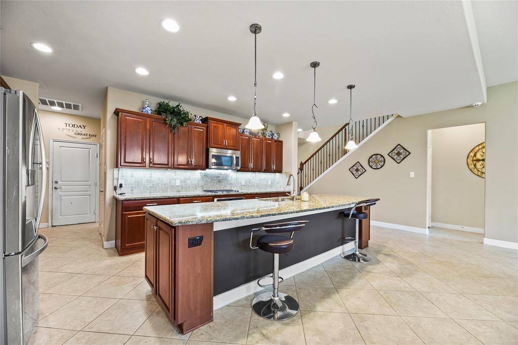 The sprawling island with breakfast bar seating serves as a versatile centerpiece, providing additional workspace, storage, and seating for casual dining or entertaining.