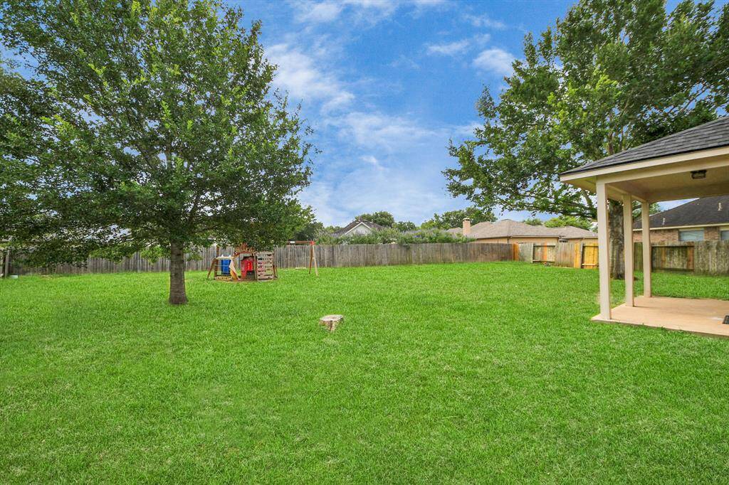 Fully fenced and green, the backyard offers plenty of room to play or plant. A pair of mid-growth trees adds balance and shade to the landscape.