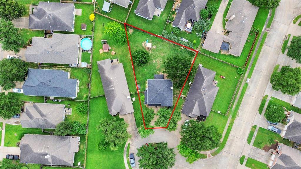 This aerial shot outlines the property footprint, showcasing the generous lot and its placement on the curve of a quiet cul-de-sac.