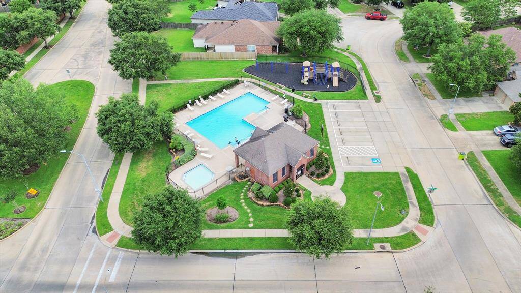 An aerial view of the nearby clubhouse reveals resort-style perks including a sparkling pool and a playground—just moments from your front door.