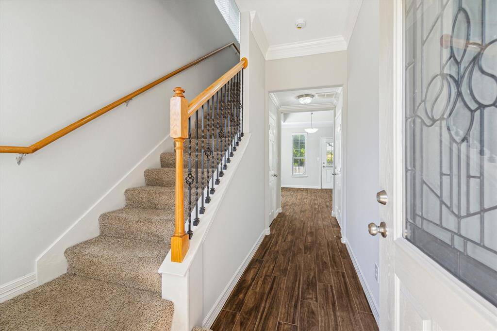Entrance into home with stairway to three bedrooms on the left
