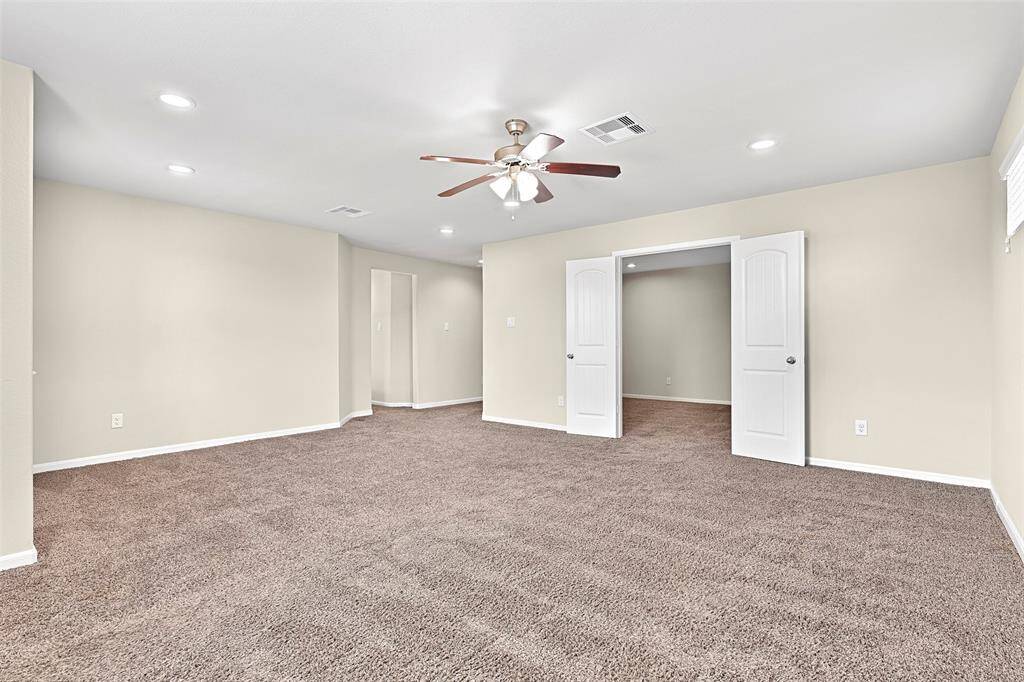 Expansive upstairs gameroom with recessed lighting, a ceiling fan, and abundant natural light—perfect for a playroom, bonus living space, or teen hangout—with double doors that open to a dedicated media room for movie nights or game day viewing.